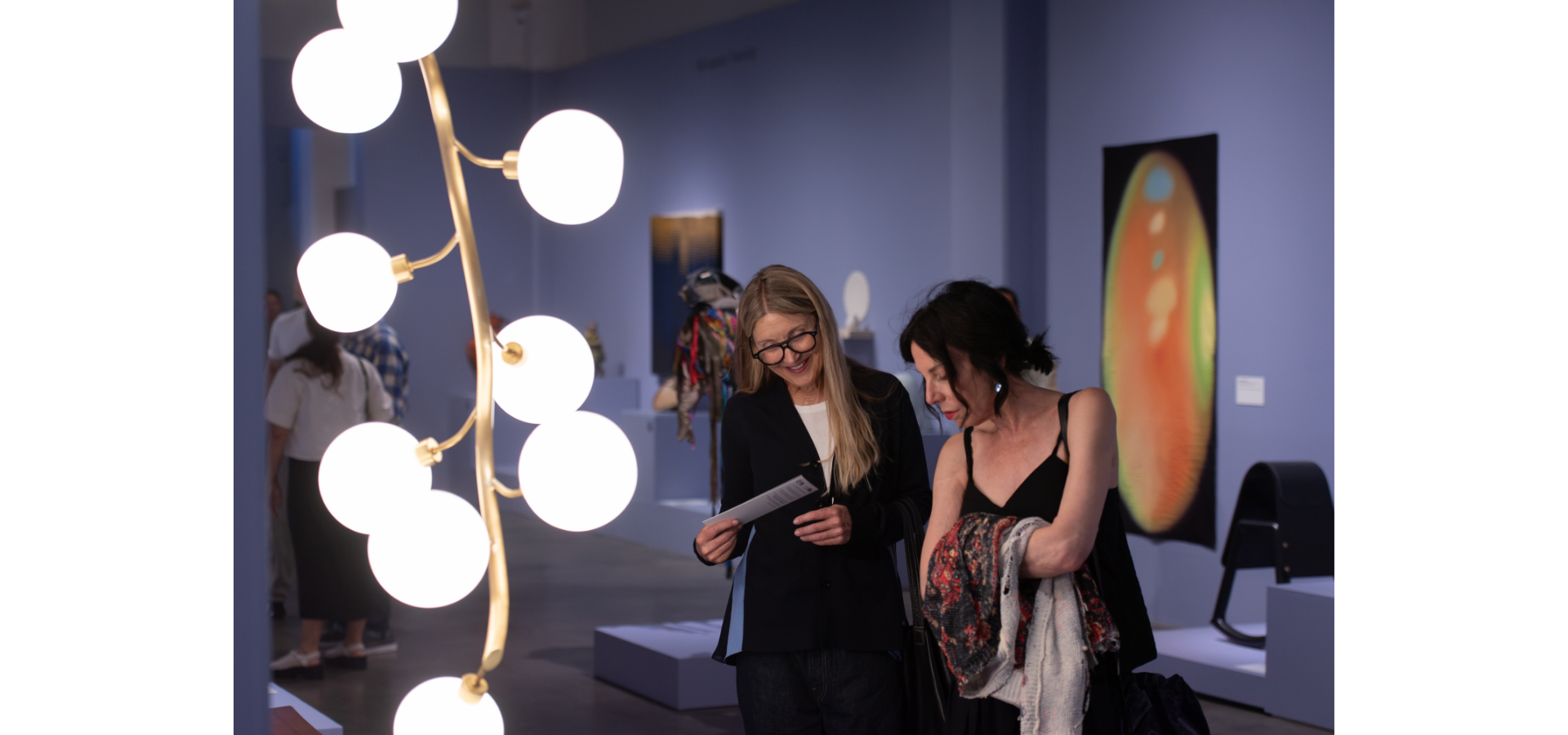 Two people look at artwork in OBJECTS: USA exhibition