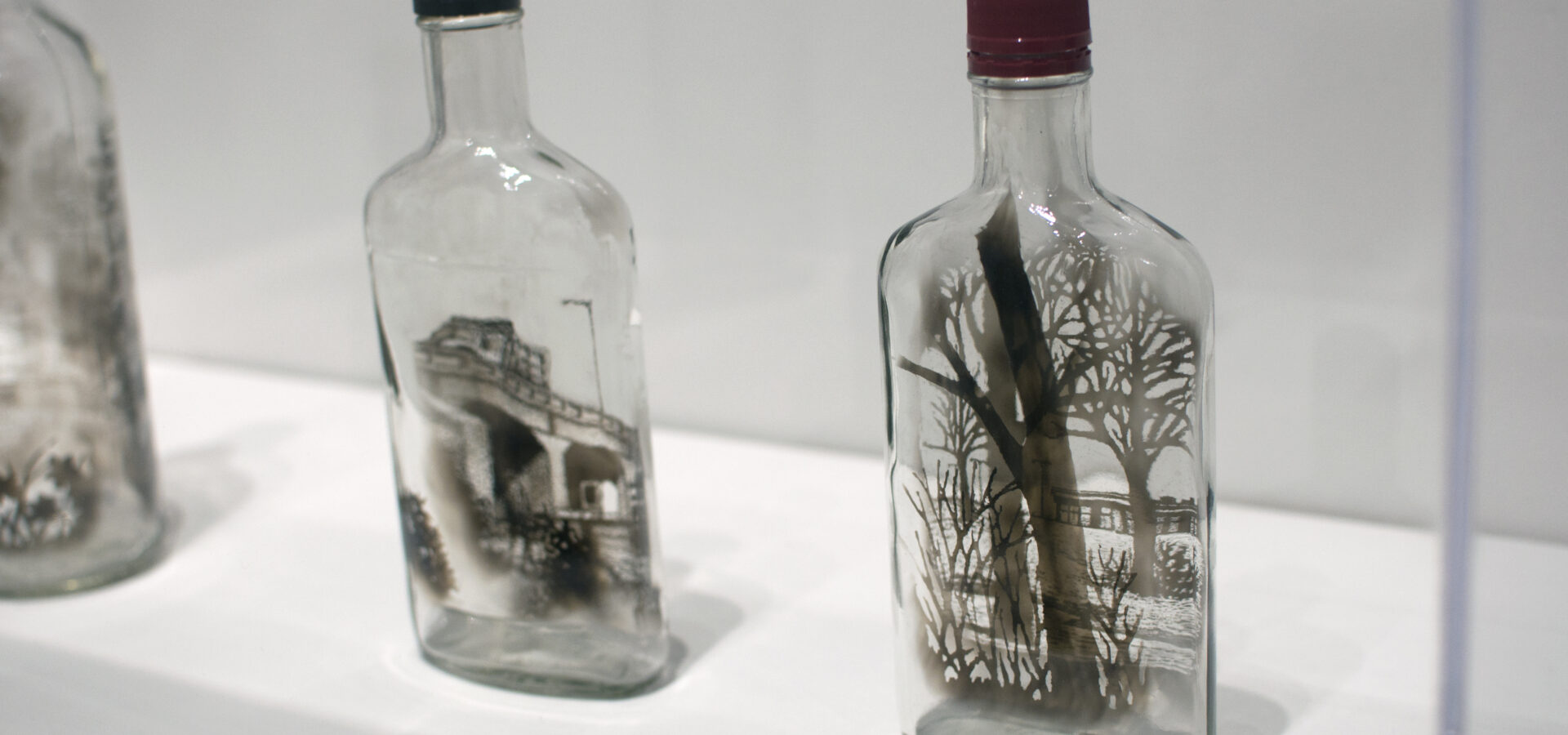Glass bottles with pieces of wood inside resembling little trees.