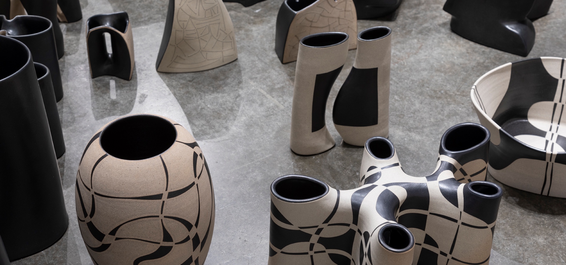 Black and white ceramics laid on the floor as seen from above