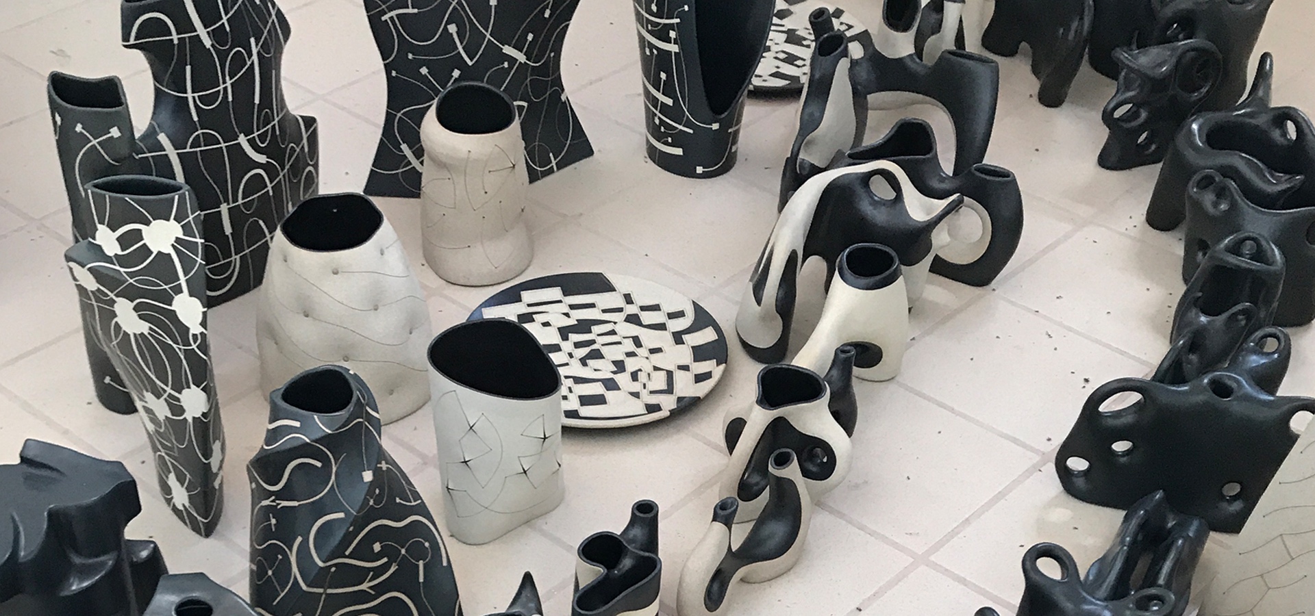 Black and white ceramics laid on the floor as seen from above