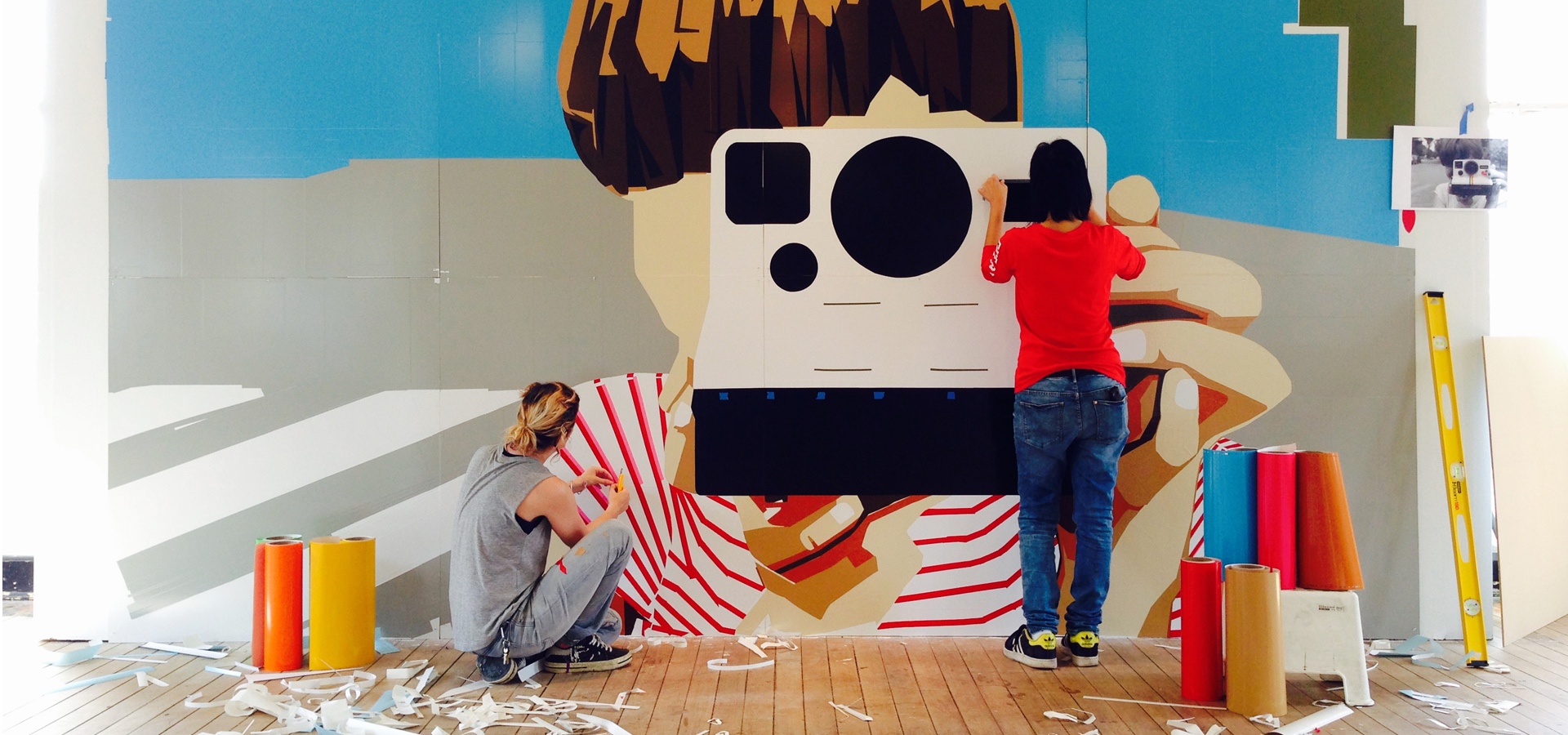 Artists installing cut vinyl wall