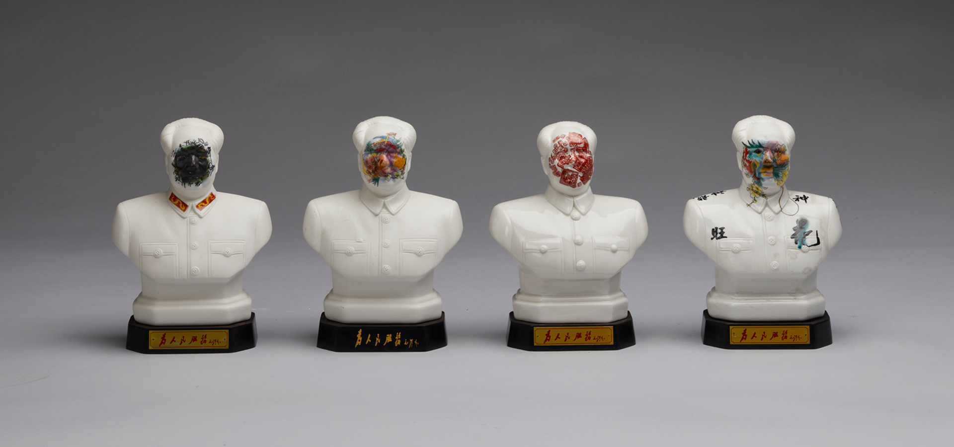 Four ceramic busts of Mao Zedong with paint covering their faces