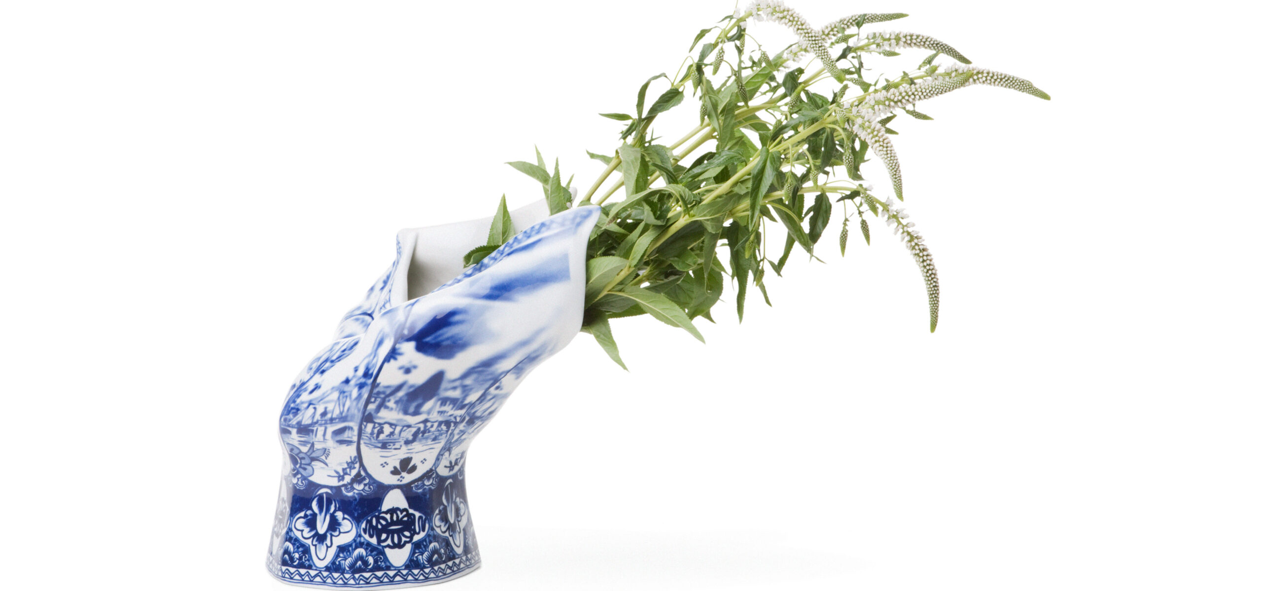 Blue and White ceramic vase bent toward right with greenery sticking out