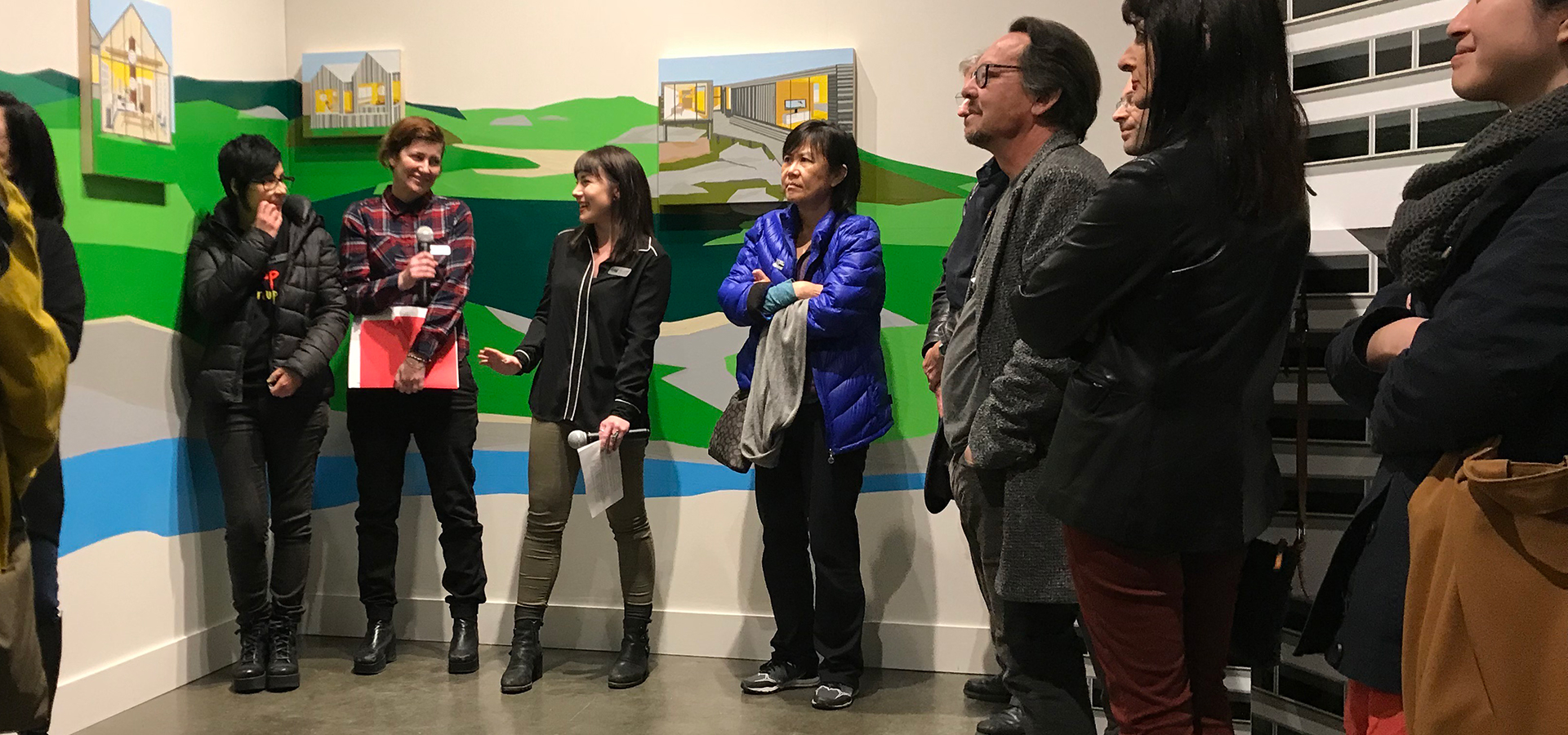 Group of people standing and listening to artist talk