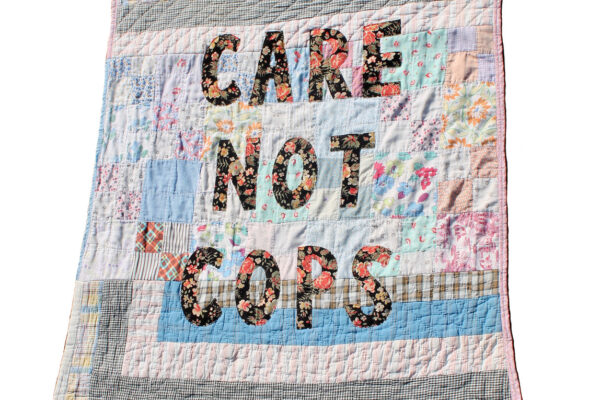 Quilt that says Care Not Cops