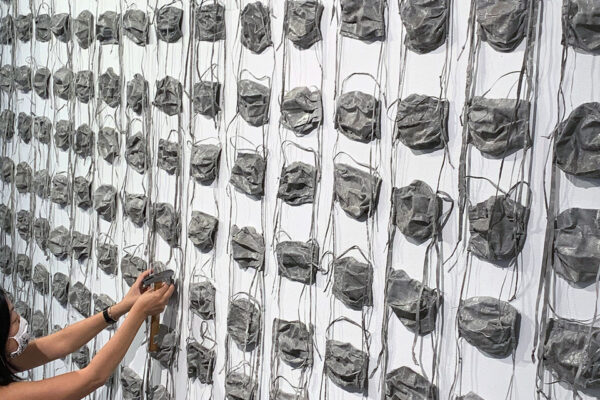 Rows of concrete surgical face masks mounted on a wall.
