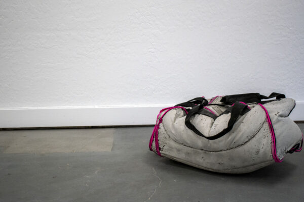 Backpacks and bags cast in concrete.