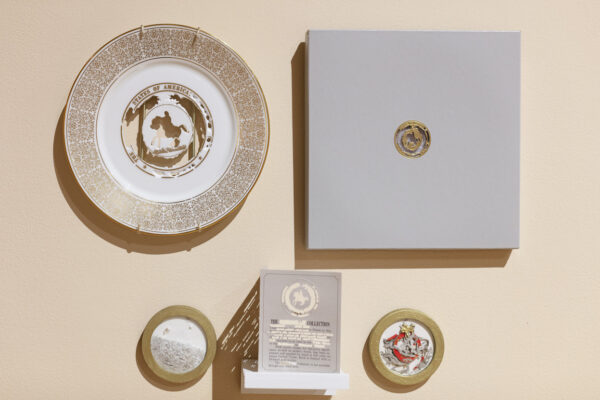 A row of porcelain plates and plaques mounted on a wall.