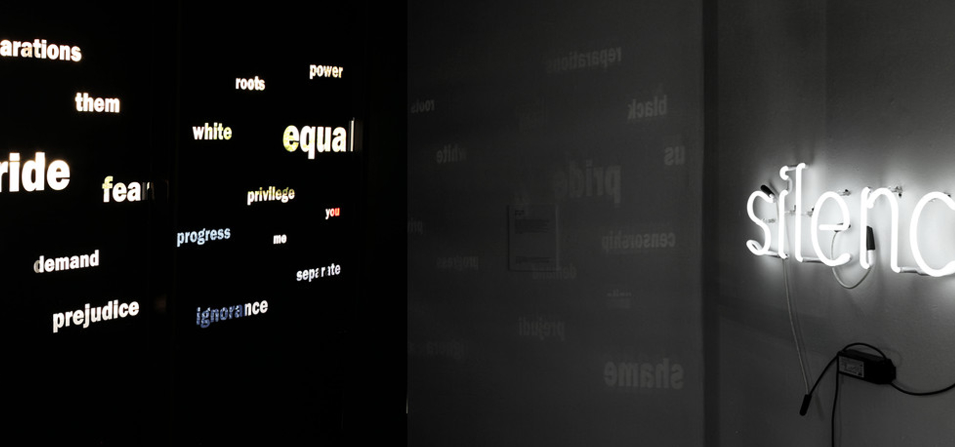 A neon wall installation with "silence" across from smaller words like "equal" across from it.