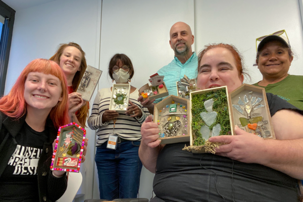 A group of people show off thier finished MakeArt projects during MAkeArt Accessible