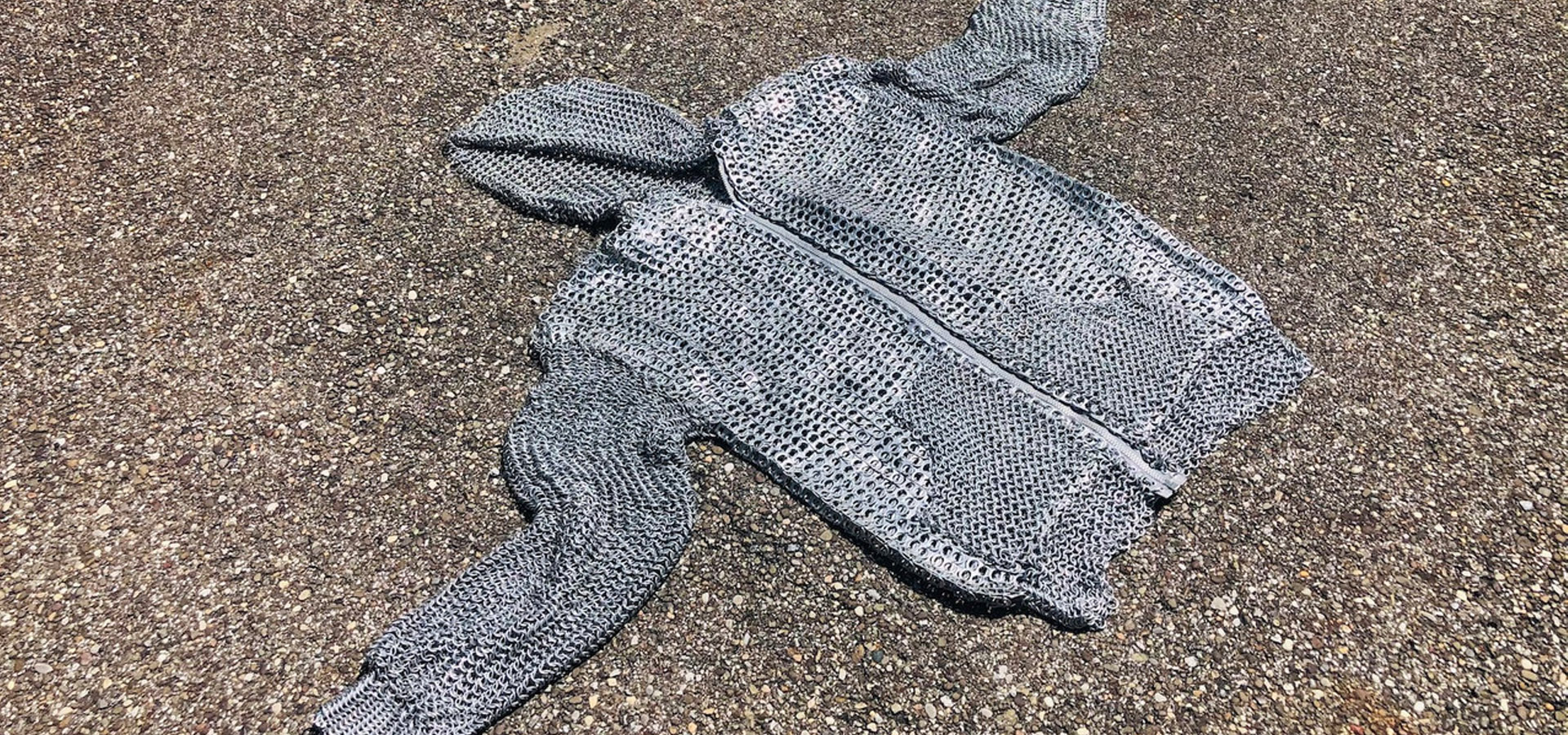 A hooded sweatershirt woven like chainmail with aluminum can tabs.