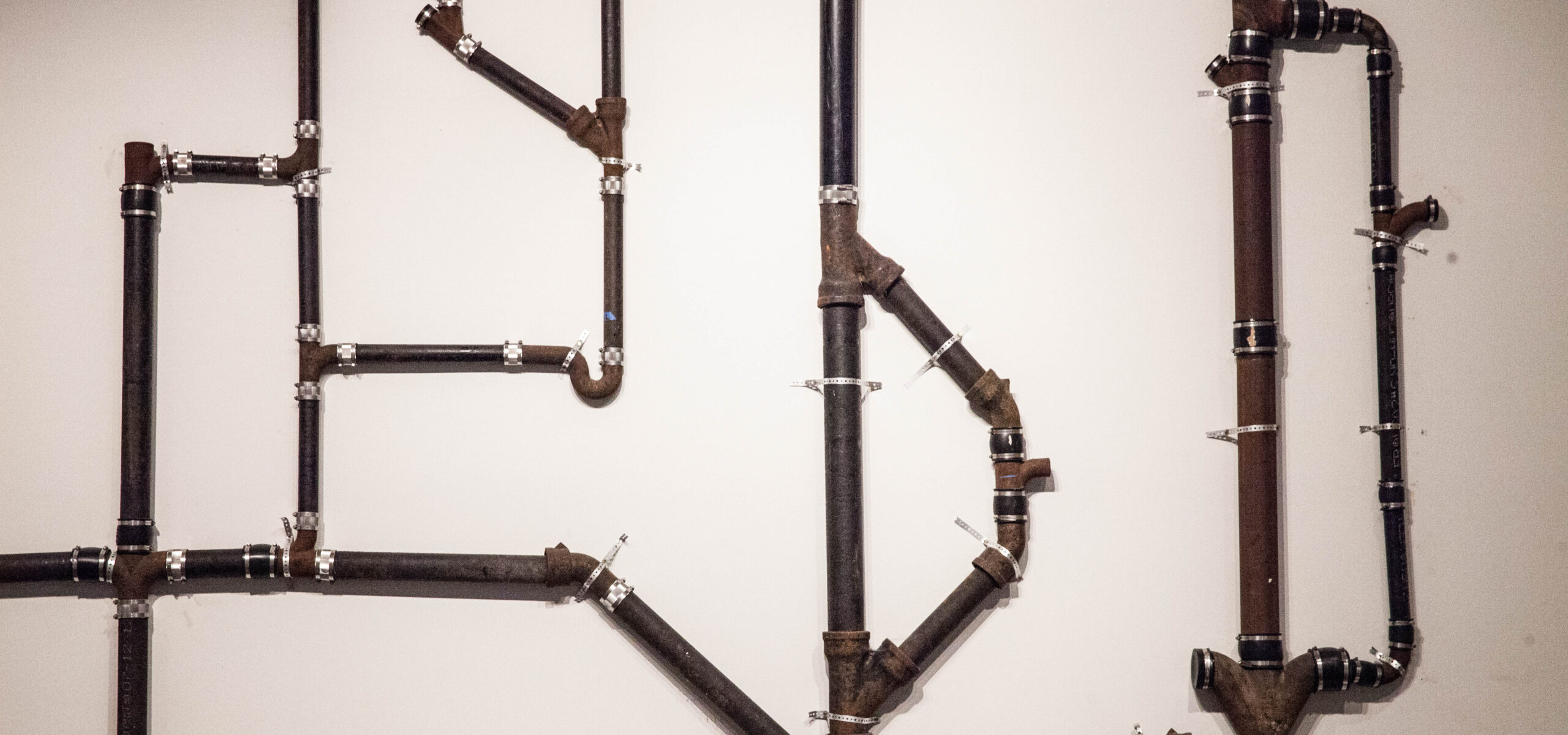 Plumbing pipes hung vertically on wall