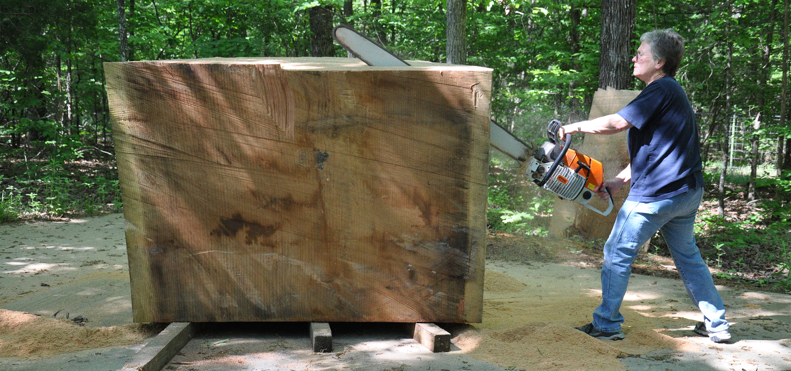 Robyn Horn sculpting with a chainsaw on a large block of wood
