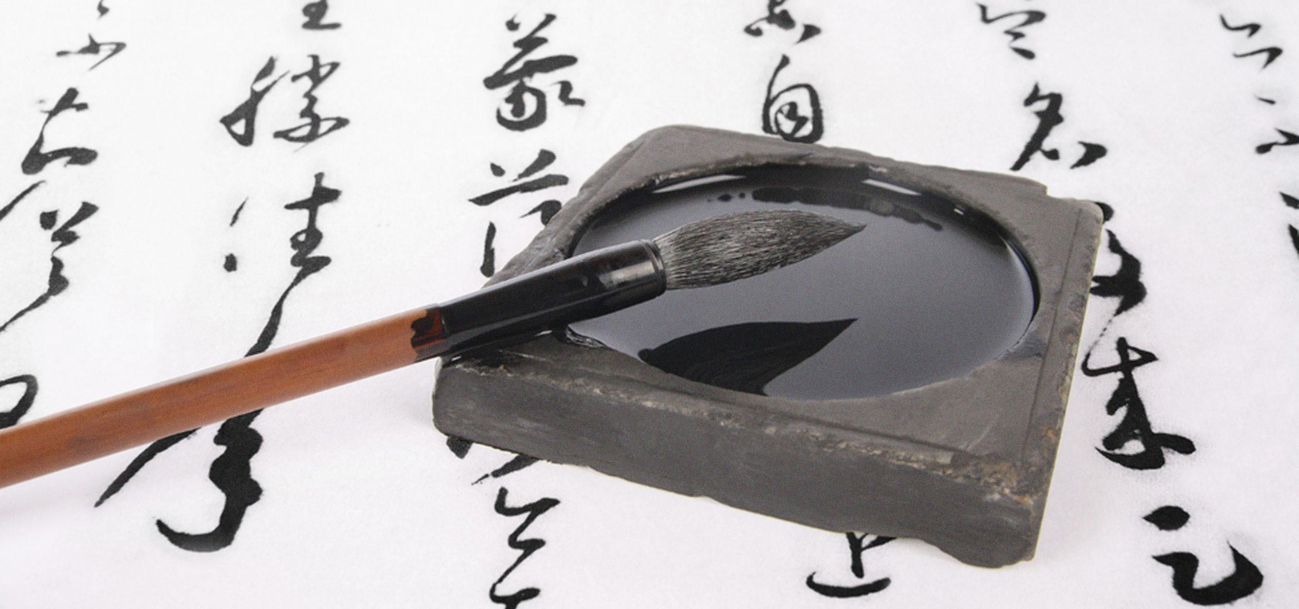 A bursh and ink on top of a piece of paper with Chinese calligraphy