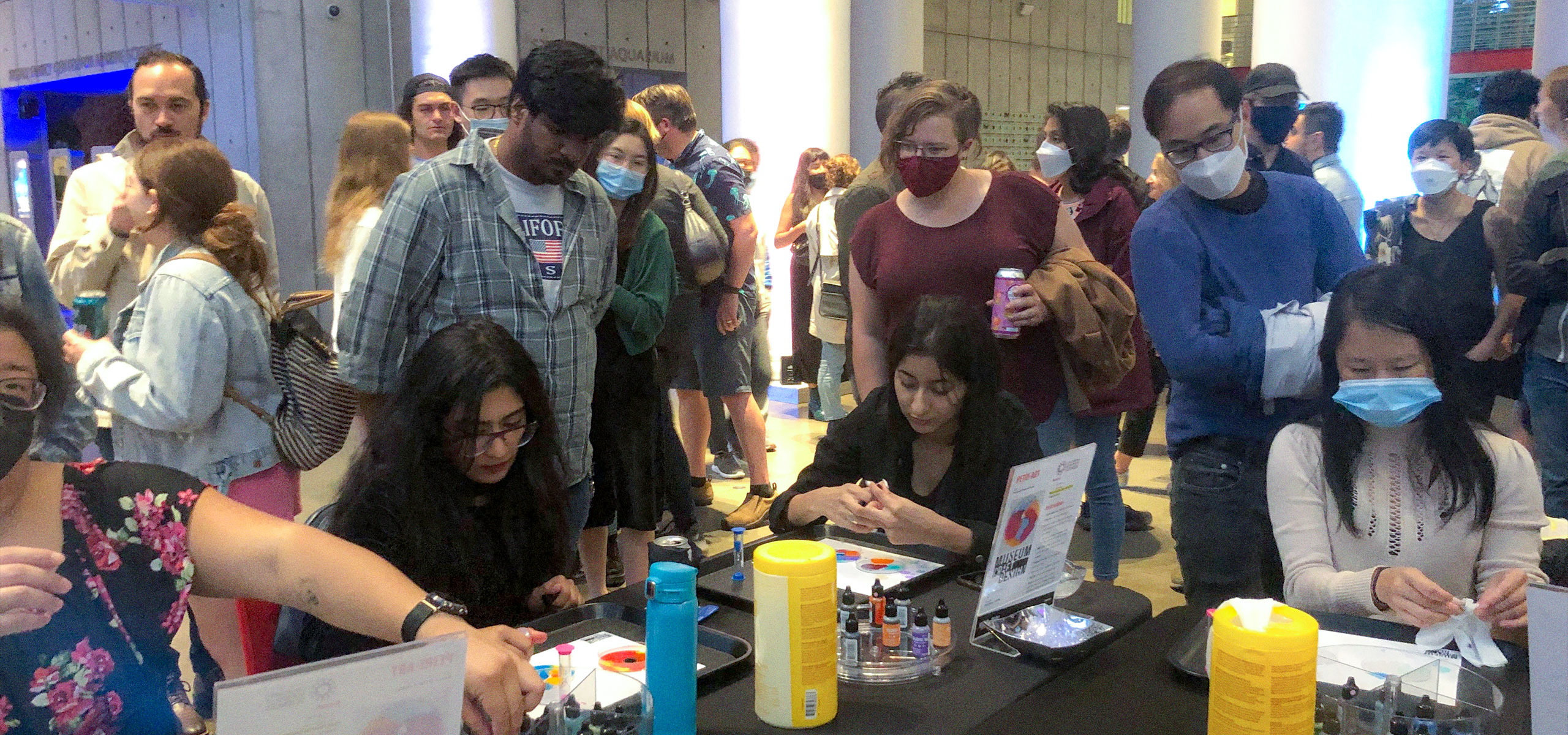 A group of people crafting at MCD's table at Cal Academy NightLife