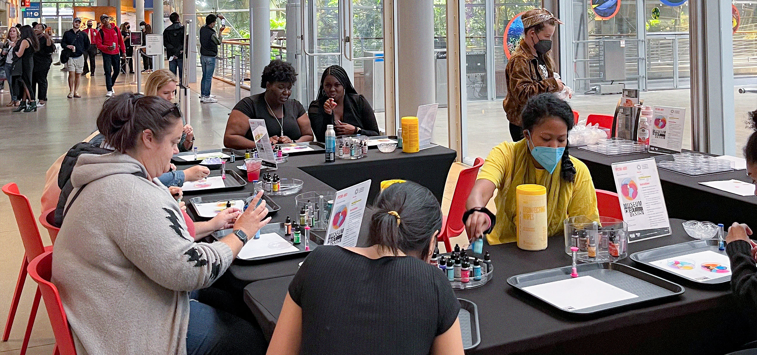 A group of people crafting at MCD's booth at Cal Academy's NightLife