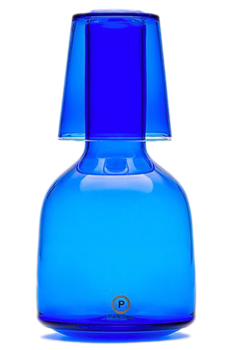 Blue Glass carafe with blue glass cup on top of it.