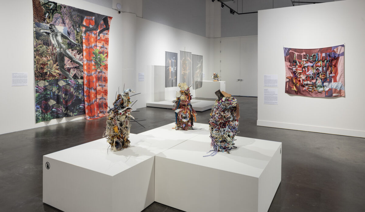 Three multi-media artwork sculptures on pedestal in museum