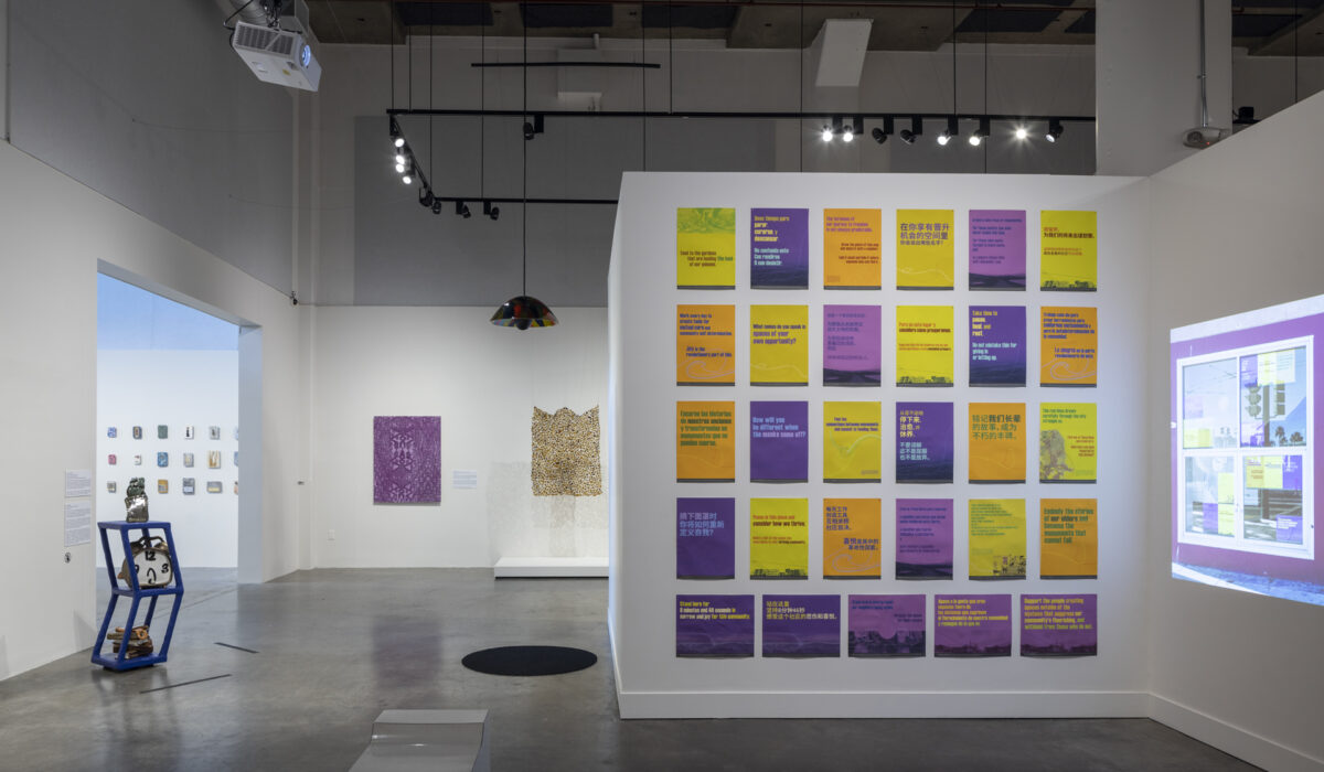 Artwork installation of yellow and purple posters and a video projection