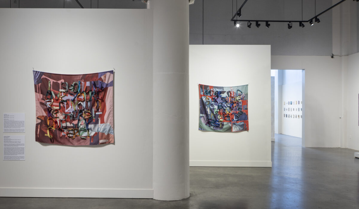 Installation view of several artworks made of hanging fabric and zippers
