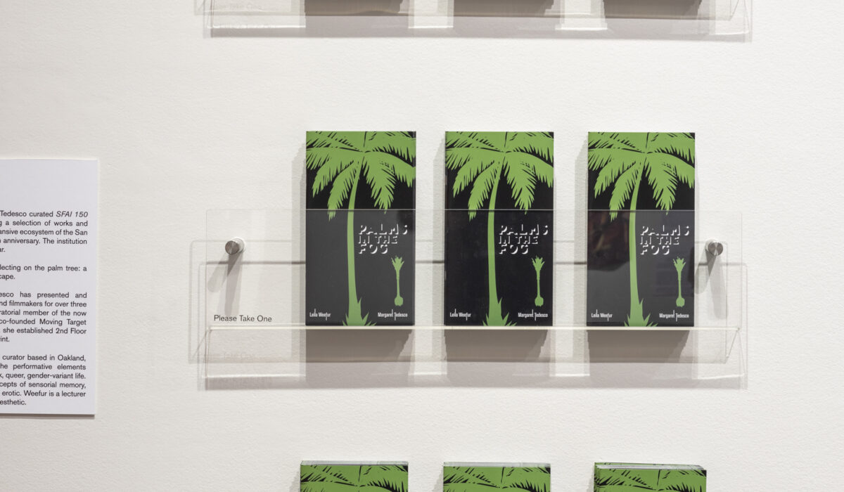 Three rows of three magazines with a green palm tree and black background hanging on the wall
