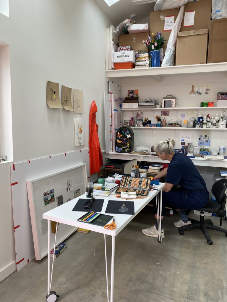 Photo of an artist studio with white table and shelves
