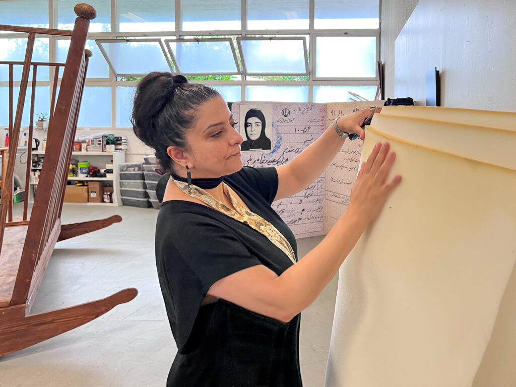 photo of Nasim Moghadam working with a large roll of foam