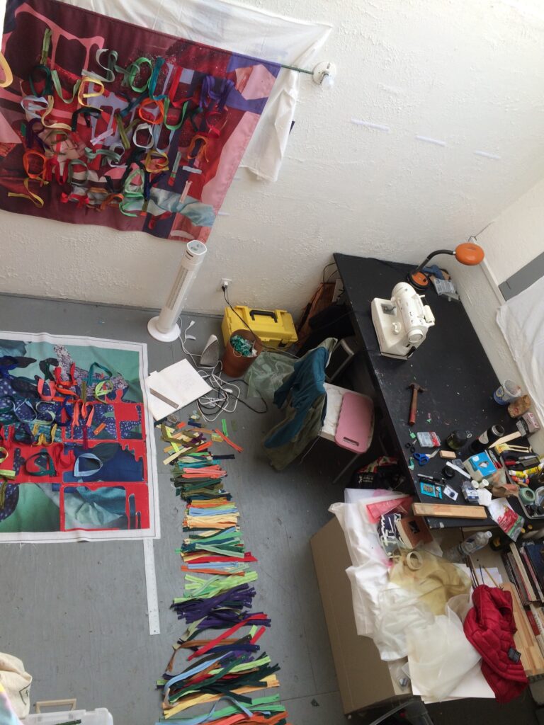 Photo of artist studio showing desk and work area from top view