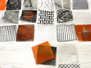 Grids of 3D Printed Textiles in black, orange and grey.