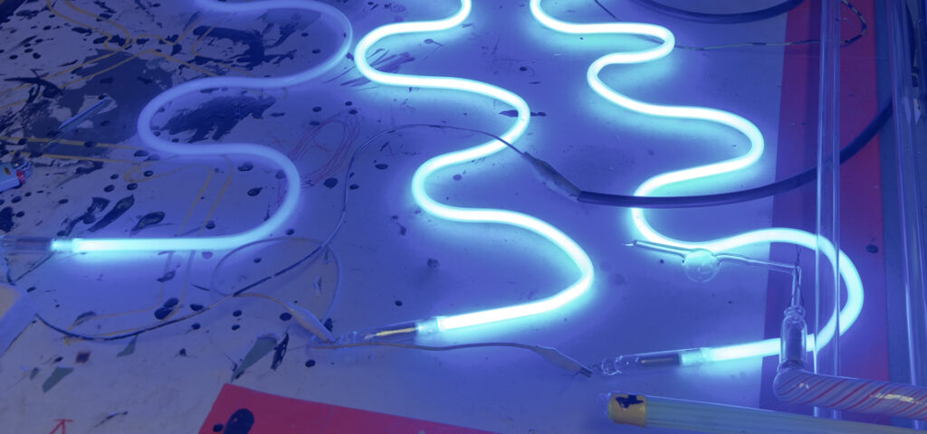 Three squiggly neon lights on a table