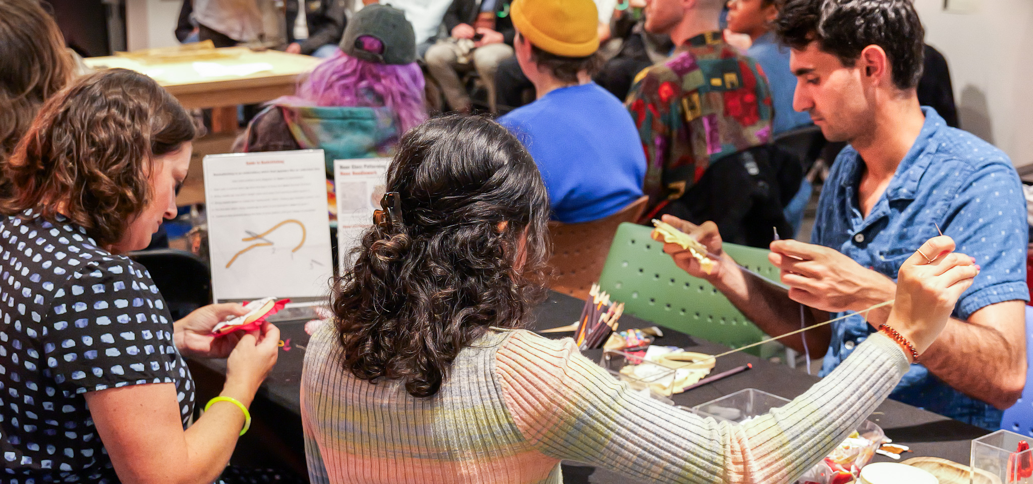 Photograph of people doing the MakeArt activation "Embrace Embroidery" in one of MCD's event