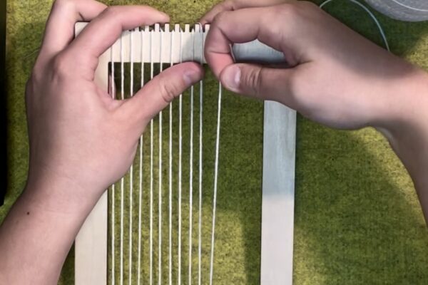 Part 1 | Prepare the Loom Step 1: Warp Loom. Tie warp thread to first top peg. Pull down and loop around corresponding peg. OPTIONAL: Increase space between warp threads by looping across multiple pegs at once. Continue up and down and left to right until at end of loom.