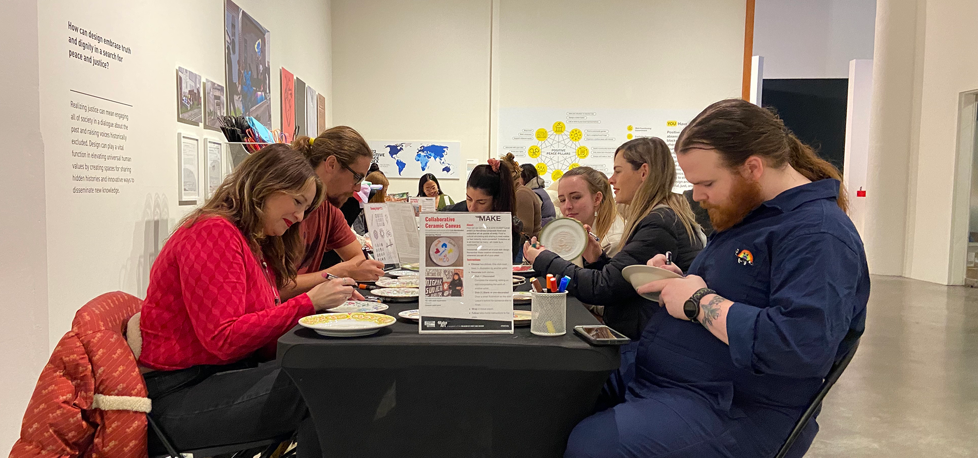 People sitting around a table and engaging in craft activities at a MakeArt activation.