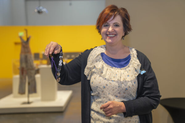 Person showing off their button necklace that they made