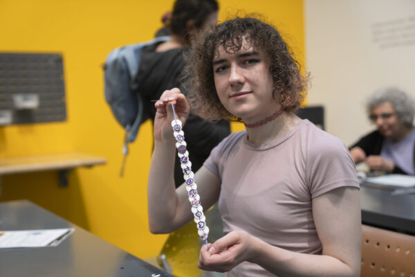 People crafting button necklaces in a museum space