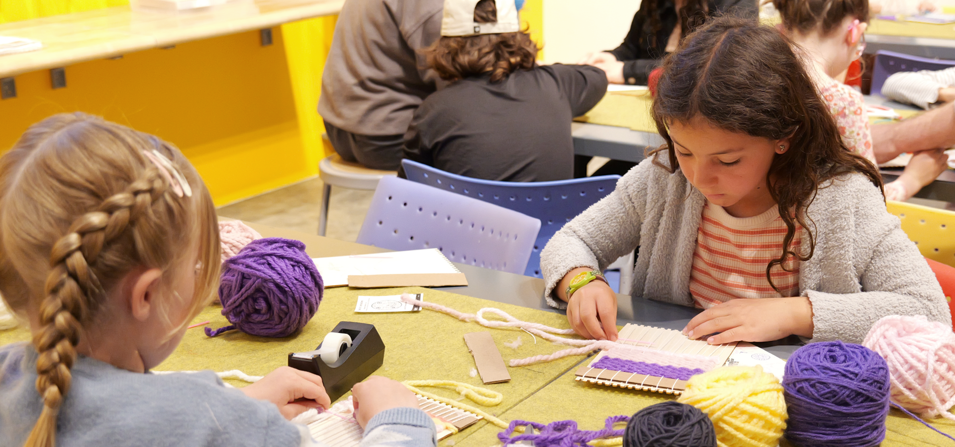 A photo of two girls participating in a craft activity in the MakeArt Lab during the MakeArt Family Day event.
