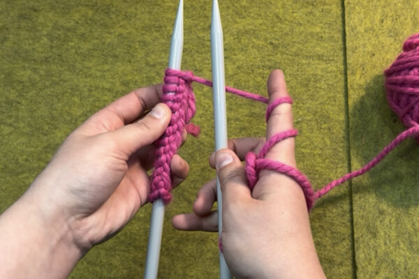 Section 2 - Knit Stitch: How to Knit: 1. Hold your needle with cast-on stitches in left hand, and other needle in right hand. 2. Orient your cast on stitches so that the ‘ridge’ or row of “V”s is facing to the right. 3. Experiment with different ways of holding your working yarn in your right hand. For consistent tension, we recommend wrapping working yarn a few times around your palm and then a few times around your index finger.