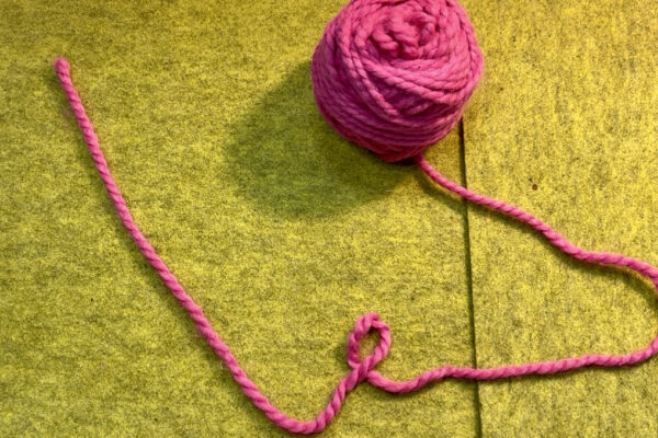 Section 1 - Casting On | Long Tail Method: Step 1 - Create a Long Tail: 1. Pull out about 18 inches of yarn from your ball. 2. Loop yarn roughly 12 inches from the start of the tail. The shorter end of the yarn should lay on top of the loop.