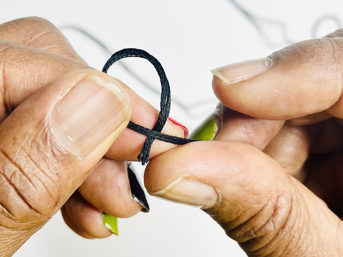 Step 1 - Thread the Needle: Loop the thread ends to make a knot and tie ends together.