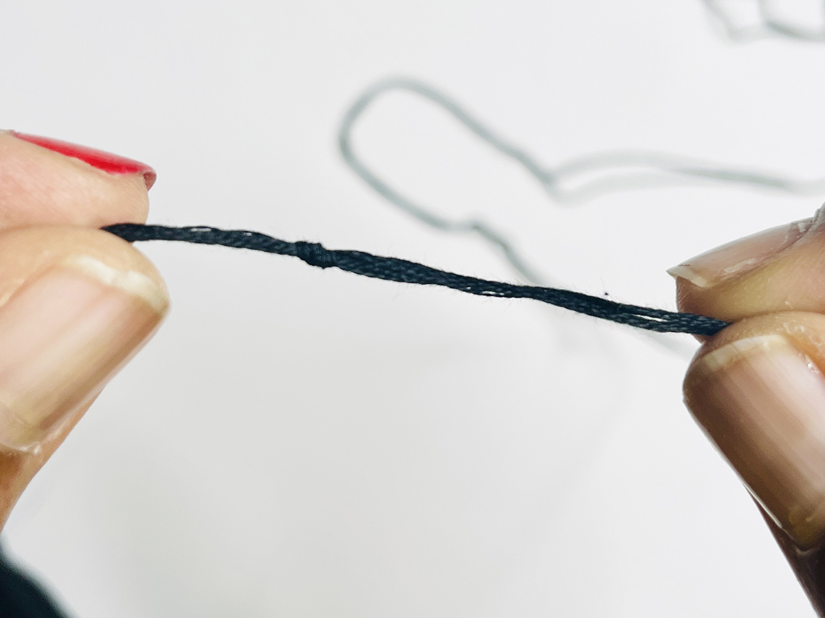 Step 1 - Thread the Needle: Loop the thread ends to make a knot and tie ends together.