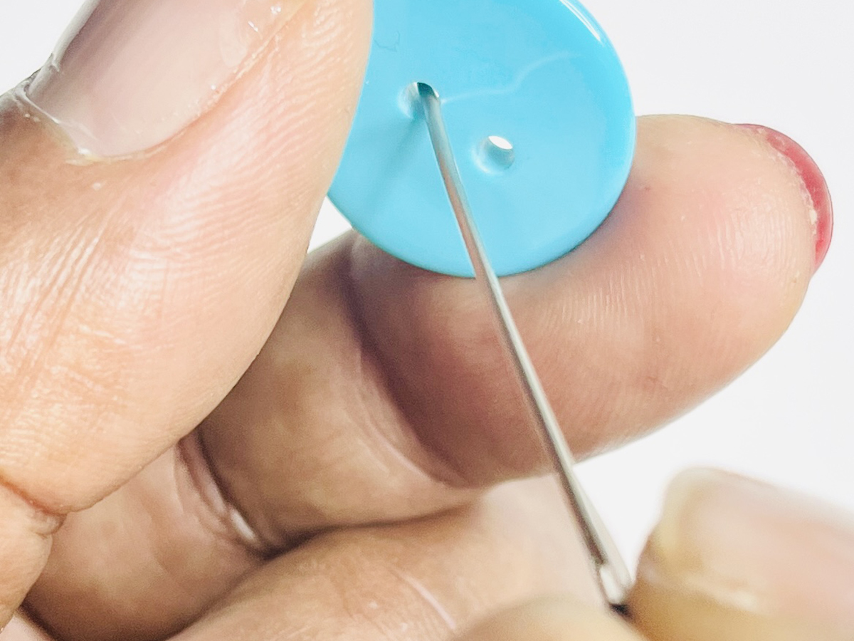 Step 2 - Add the First Button: 1. Place the needle through the first buttonhole.