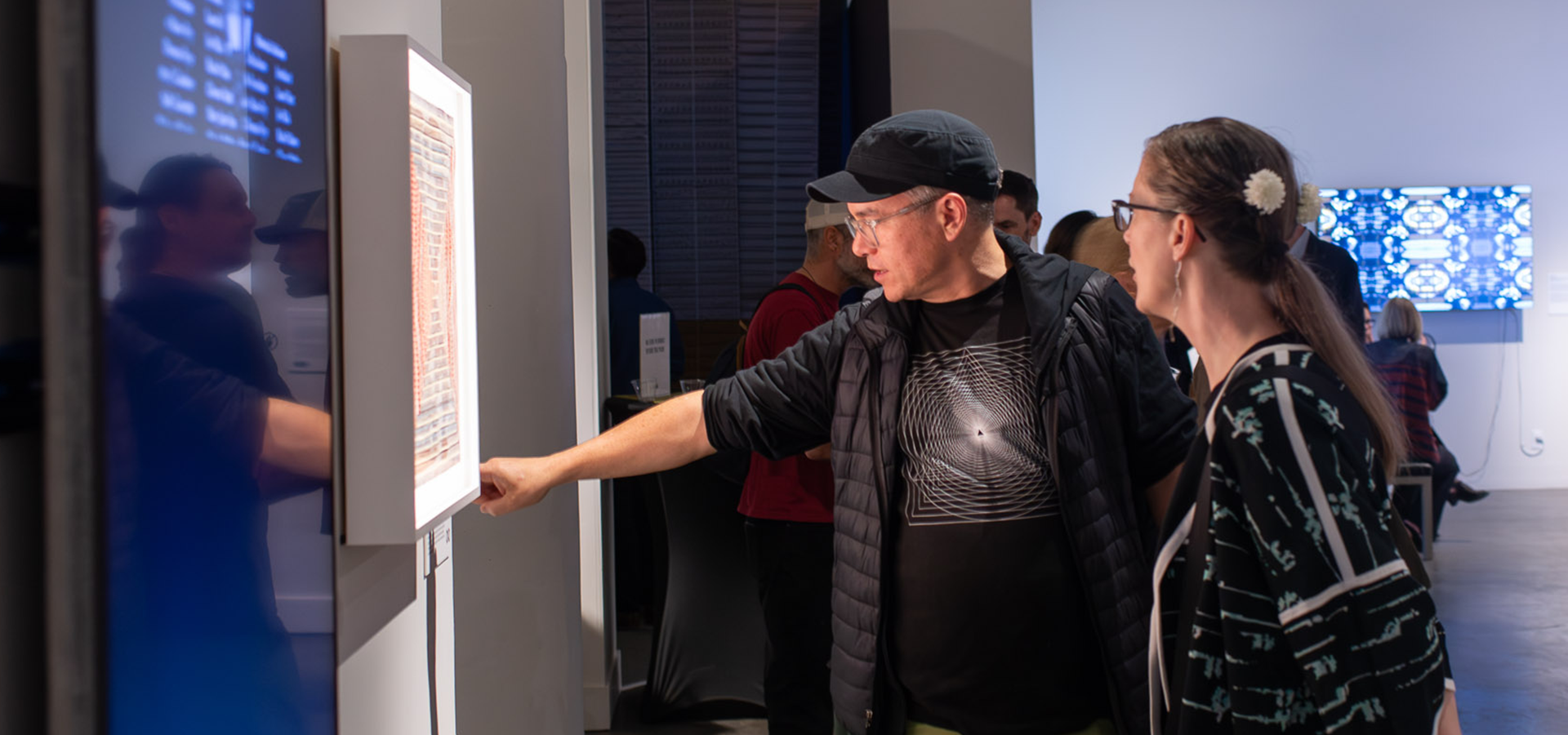 two visitors viewing artworks in MCD's "Video Craft" exhibition